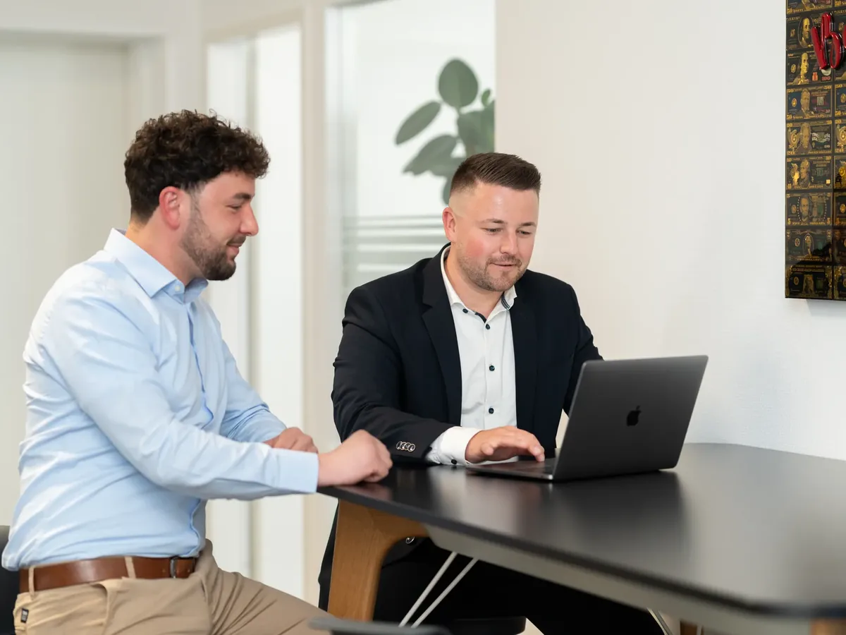 Berater von CODE FINANCE kalkuliert Beitragsentwicklung am Laptop